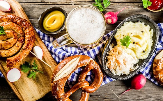Bratwurst, pretzels, sauerkraut and mashed potato on a checked cloth